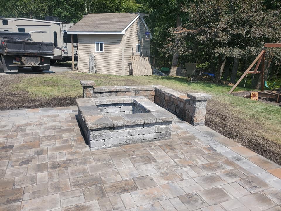 Paver patio with built-in stone fire pit and seating walls