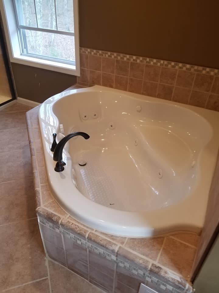 Luxury master bathroom with jetted tub and tile surround