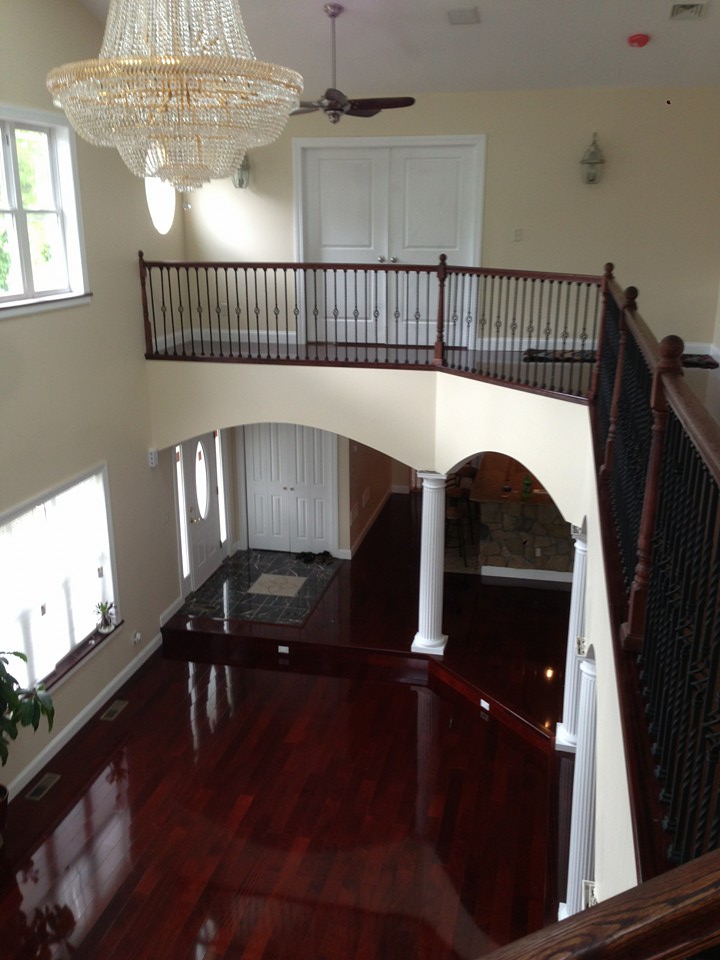Two-story foyer with cherry hardwood floors and wrought iron railings