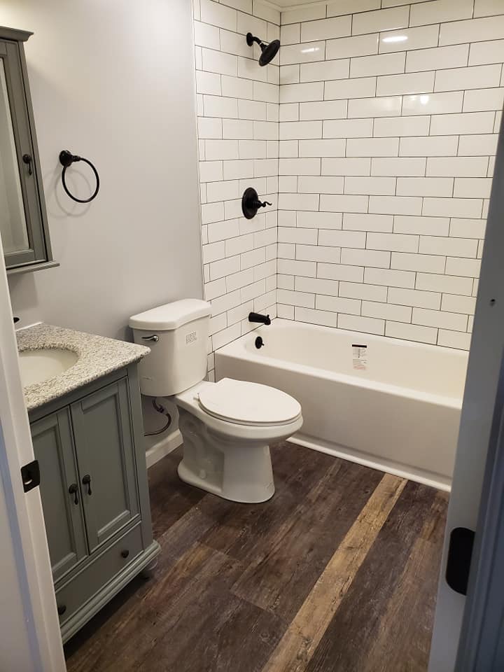 Bathroom renovation with subway tile shower and wood-look floor